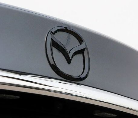 Купити Емблема Mazda 115&times;93мм Чорна пластик (на скотчі та з 2 напрямними) (вир-во Завод) CH 90370 Емблеми на іномарки